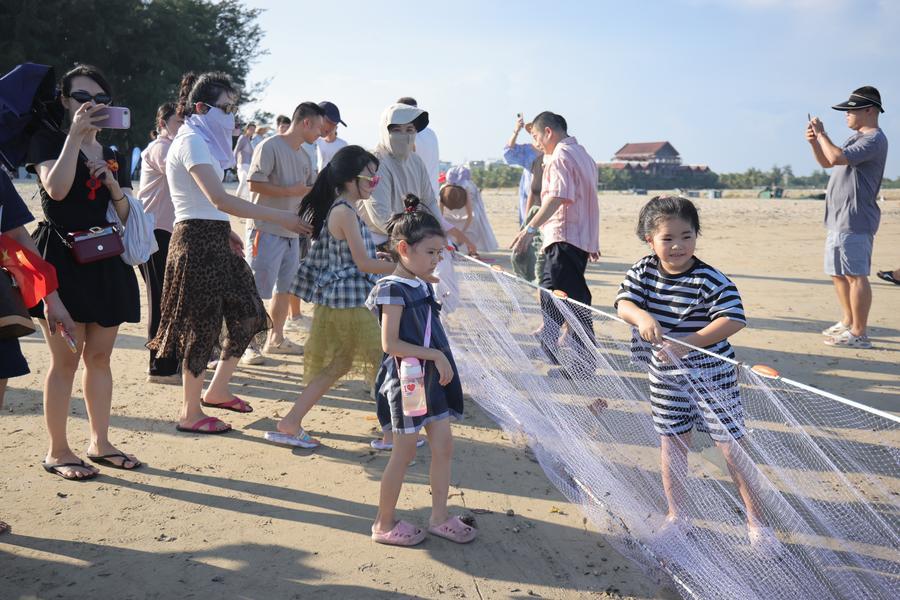 지난 2일 하이난(海南)성 충하이(瓊海)시 탄먼(潭門)진 해변에서 관광객들이 전통 그물낚시 체험을 하고 있다. (사진/신화통신)
