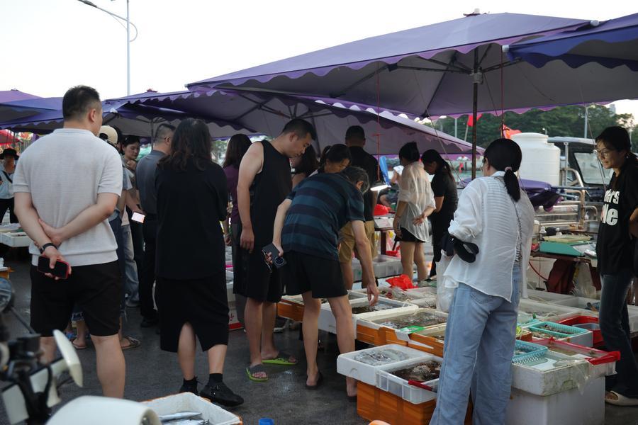 2일 탄먼진 푸강루(富港路)를 따라 들어선 해산물 시장에서 관광객이 해산물을 구매하고 있다. (사진/신화통신)