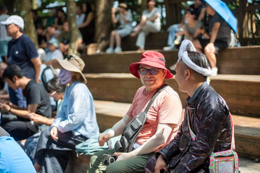 외국인 관광객이 지난 8월 20일 구이저우(貴州)성 첸둥난(黔東南) 먀오(苗)족둥(侗)족 자치주 충장(從江)현 바사(岜沙)촌에서 마을 주민과 이야기를 나누고 있다. (사진/신화통신)