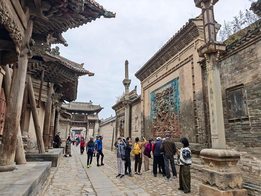 관광객들이 3일 펀청고진 성황묘(城隍廟) 앞 유리조벽(琉璃照壁,중국에서 문 안에 설치하는 가리개)에서 기념촬영을 하고 있다. (사진/신화통신)